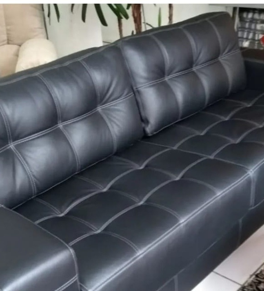 Sofá de couro preto com capitonê e costura aparente